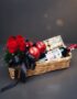 Arreglo ANGELO: Elegante cesta de mimbre con rosas rojas frescas, manzanas rojas, botella de vino tinto Finca Las Moras y caj