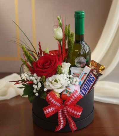 Arreglo floral CARLO con rosas rojas y blancas, vino verde, chocolates Kinder y Snickers en caja negra con lazo a cuadros roj