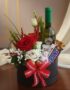 Arreglo floral CARLO con rosas rojas y blancas, vino verde, chocolates Kinder y Snickers en caja negra con lazo a cuadros roj