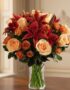 Arreglo Floral ALESSANDRA con rosas naranjas y lirios frescos en un jarrón de cristal, sobre una mesa de madera oscura con un