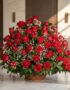 Arreglo Floral Amor Gigante con rosas rojas frescas y follaje verde en una cesta de mimbre, sobre una superficie de mármol pu