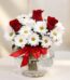 Arreglo floral Antonietta con rosas rojas, margaritas blancas y lazo rojo en jarrón de cristal, ideal para regalar en ocasion