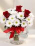 Arreglo floral Antonietta con rosas rojas, margaritas blancas y lazo rojo en jarrón de cristal, ideal para regalar en ocasion