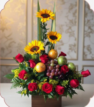 Arreglo floral Batista con rosas rojas, girasoles vibrantes, uvas, mandarinas y manzanas verdes en una base de madera, ideal