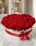 Arreglo floral CAMILA con 24 rosas rojas premium en una elegante caja blanca en forma de corazón, adornada con un lazo rojo,