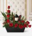 Arreglo floral CINZIA con 12 rosas rojas frescas, follaje verde variado y una botella de vino tinto, presentado en una base n