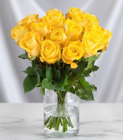 Arreglo floral Elisabetta con 18 rosas amarillas frescas en un jarrón de cristal, ideal para expresar amistad y gratitud.