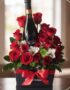 Arreglo floral ENNIO con rosas rojas vibrantes, alstroemerias blancas y vino tinto, presentado en caja negra con lazo rojo.