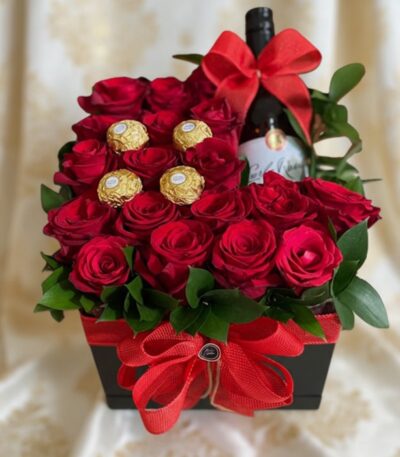 Arreglo floral ENRICO con rosas rojas frescas, botella de vino tinto y chocolates Ferrero Rocher, presentado en una caja negr