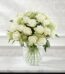 Arreglo floral Estefanía con 24 rosas blancas frescas en un jarrón de cristal sobre una mesa de mármol, con un fondo elegante