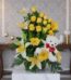 Arreglo floral exótico Amaretto con rosas amarillas, lirios blancos y gerberas, acompañado de un oso de peluche blanco con la