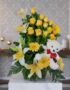 Arreglo floral exótico Amaretto con rosas amarillas, lirios blancos y gerberas, acompañado de un oso de peluche blanco con la
