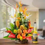 Arreglo floral exótico Apolo con aves del paraíso, rosas naranjas, anturios rojos y jengibre, acompañado de una cerveza Coron