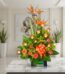 Arreglo floral exótico Esplendor con aves del paraíso y rosas, sobre mesa de mármmol en un elegante lobby de hotel boutique.