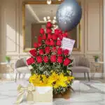 Arreglo floral exótico Gamma con rosas rojas, lirios amarillos y follaje verde, presentado en un entorno elegante y lujoso.