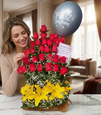 Mujer sonriente admirando un Arreglo Floral Exótico Gamma con rosas rojas, lirios amarillos y un globo de "Feliz Cumpleaños"