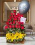 Arreglo floral exótico Gamma con rosas rojas, lirios amarillos y un globo de 'Feliz Cumpleaños' sobre una mesa de mármol en u