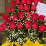 Primer plano extremo de Arreglo Floral Exótico Gamma, mostrando rosas rojas con gotas de rocío, flores blancas y lirios amari