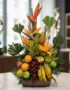 Arreglo floral exótico 'Bahamas' con aves del paraíso, lirios naranjas, hojas tropicales, uvas, manzanas, peras, naranjas y p