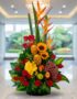 Arreglo floral premium con rosas rojas, girasoles, aves del paraíso, frutas durio, uvas y manzanas, sobre mármol en un lobby