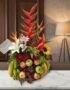 Arreglo floral premium 'Eclipse' con heliconias, lirios, girasoles y frutas frescas como manzanas, uvas y plátanos, sobre una