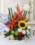 Arreglo floral con frutas tamarillo, girasoles, rosas blancas, heliconias y globo 'Feliz Día' en base de madera, ideal para e