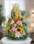 Arreglo floral exótico y vibrante con frutas, lirios, girasoles y aves del paraíso sobre una base de mármol en un entorno ele