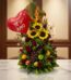 Arreglo floral premium con girasoles, rosas rojas, frutas tropicales (uvas, manzanas, naranjas) y un globo rojo de corazón co
