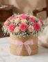 Arreglo floral GIADA con 12 rosas frescas rosadas y crema en una caja redonda de cartón con lazo rosa, ideal para regalo.