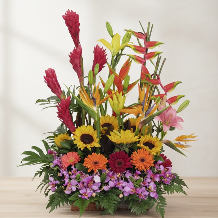 Arreglo floral GINGER exótico con orquídea hawaiana, heliconias, jengibre rojo, girasoles y gerberas en tonos vibrantes sobre