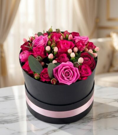 Arreglo floral LILIAN en caja negra con cinta rosa, lleno de rosas lila y rojas, ideal para regalar.