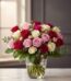Arreglo floral LUCREZIA con 30 rosas en tonos románticos (rojas, rosas y blancas) en un jarrón de cristal, sobre una mesa de
