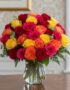 Arreglo floral MARIELLA con 36 rosas frescas en tonos rojo, amarillo, fucsia y naranja, presentado en un elegante jarrón de c