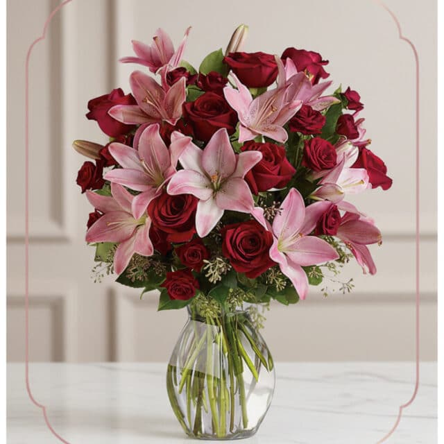 Arreglo floral Nabila con 30 rosas rojas y lirios rosados en un jarrón de cristal, ideal para ecommerce.