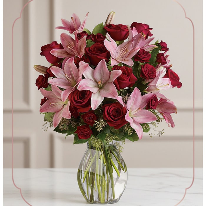 Arreglo floral Nabila con 30 rosas rojas y lirios rosados en un jarrón de cristal, ideal para ecommerce.