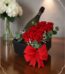 Arreglo floral NATALE con rosas rojas frescas, vino espumoso y lazo rojo en caja negra, ideal para regalo elegante.