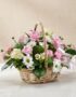 Cesta de mimbre con 12 rosas rosadas, margaritas blancas, freesias y claveles, ideal para regalar en ocasiones especiales.