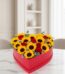 Arreglo floral RINA en forma de corazón con girasoles vibrantes y rosas rojas, ideal para expresar amor y alegría en cualquie