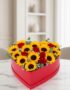 Arreglo floral RINA en forma de corazón con girasoles vibrantes y rosas rojas, ideal para expresar amor y alegría en cualquie