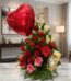 Arreglo floral 'Te Amo' con rosas rojas, lirios blancos, gerberas rosadas y rojas, follaje verde, un globo de corazón rojo y