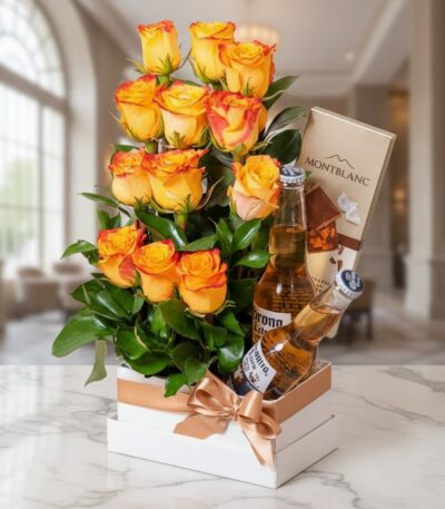 Arreglo floral Zeus con rosas amarillas y naranjas, dos cervezas Corona y chocolates Montblanc en un elegante fondo de lobby