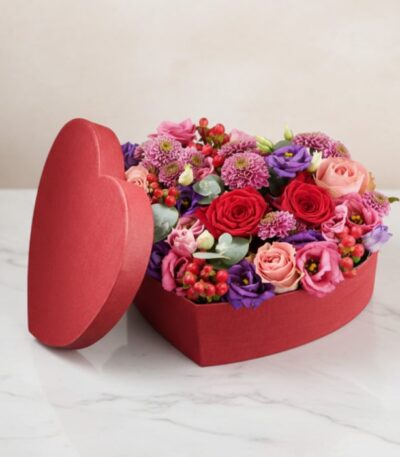 Arreglo floral ZITA en caja de corazón roja con rosas rojas, rosadas y flores mixtas, ideal para regalar en ocasiones especia