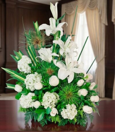 Arreglo fúnebre Adiós Para Siempre con lirios, hortensias y rosas blancas, en una sala de velación premium con luz natural y