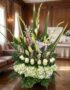 Arreglo floral fúnebre 'Eterno Descanso' con lirios, rosas blancas e hortensias, en una sala de velación premium con luz natu