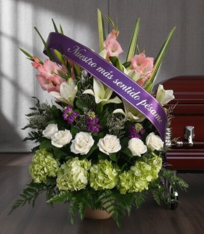 Arreglo floral fúnebre 'Te Fuiste' con lirios blancos, gladiolos rosados y hortensias verdes, adornado con una cinta morada d
