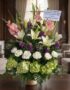 Arreglo fúnebre Te Fuiste con lirios blancos, gladiolos rosas, rosas blancas y hortensias verdes, en sala de velación premium