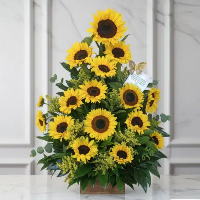 Arreglo floral de girasoles radiantes en un jarrón de madera, sobre una superficie de mármol, con un fondo elegante y luminos