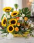 Arreglo floral vibrante con girasoles, rosas blancas y naranjas, follaje verde y tres botellas de cerveza Corona, ideal para
