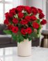 Arreglo floral Jianna con 25 rosas rojas frescas en un elegante jarrón blanco sobre mesa de mármol, fondo difuminado de sala