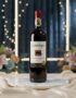 Botella de vino tinto Gato Negro Cabernet Sauvignon en un elegante estudio con arreglo floral y luces cálidas, ideal para eco